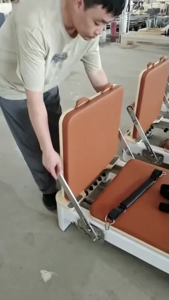 Worker checking a Pilates equipment adjustment