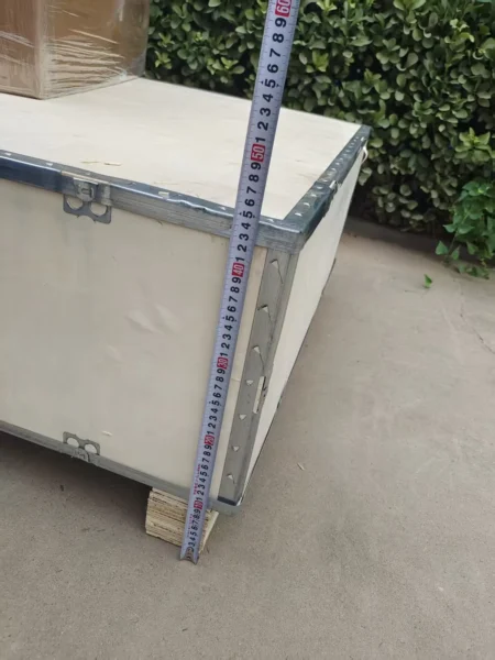 Measuring a wooden equipment crate before packing confirmation