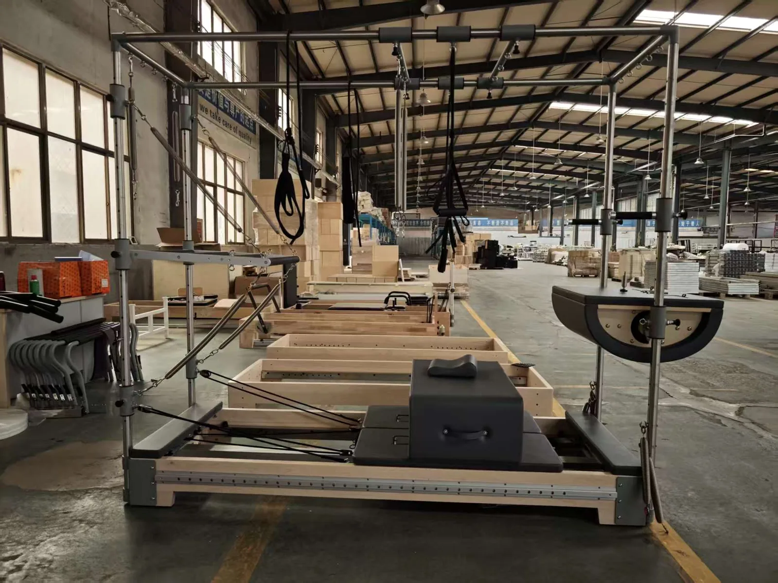 Pilates equipment and components arranged on the production floor.
